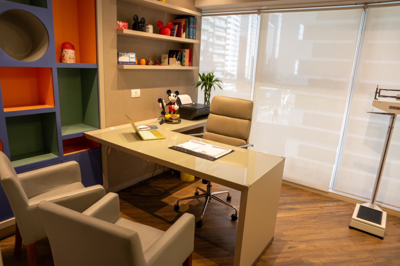 Consultório do Dr. Victor Horácio na Clínica Doutor Kids, com mesa de atendimento e balança pediátrica