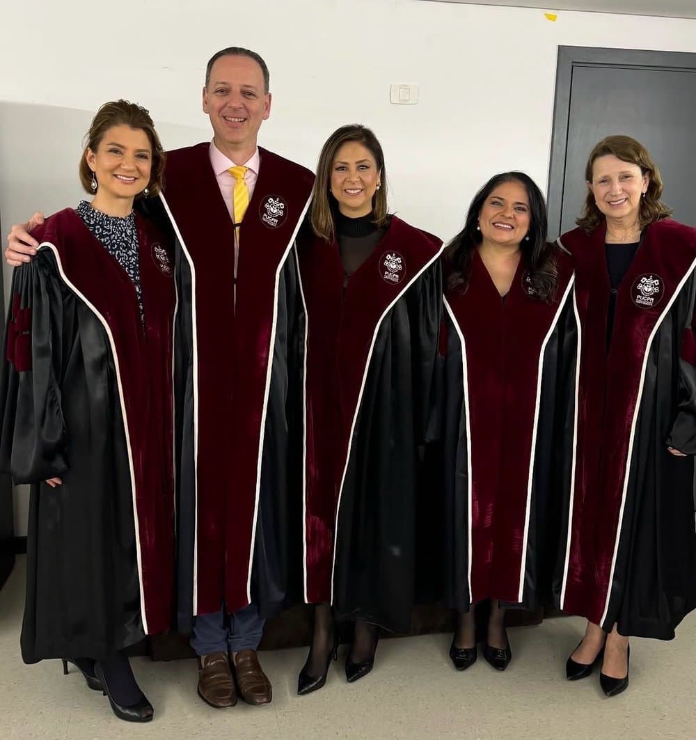 Dr. Victor Horácio de beca entre colegas docentes na formatura de Medicina da PUCPR